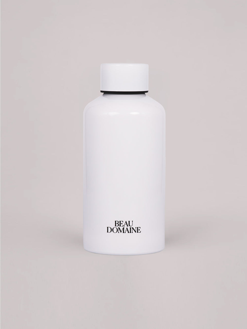 Weiße Flasche mit „Beau Domaine"-Branding auf beigem Hintergrund